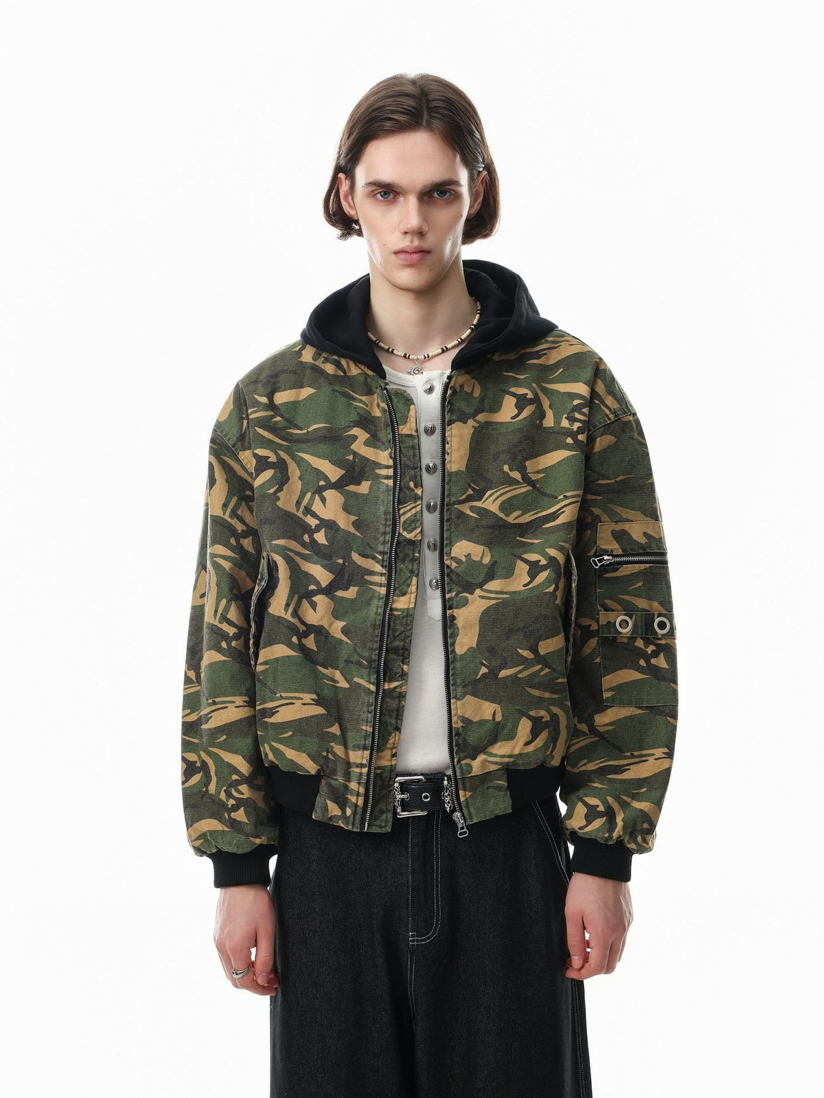 Oversized camo padded bomber jacket with black hood, grommet sleeve detail, and ribbed cuffs shown front and back
