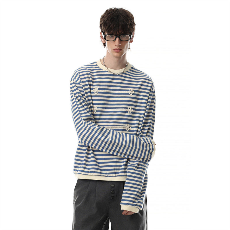 Model wearing blue and cream striped long sleeve shirt with contrast trim, arms crossed