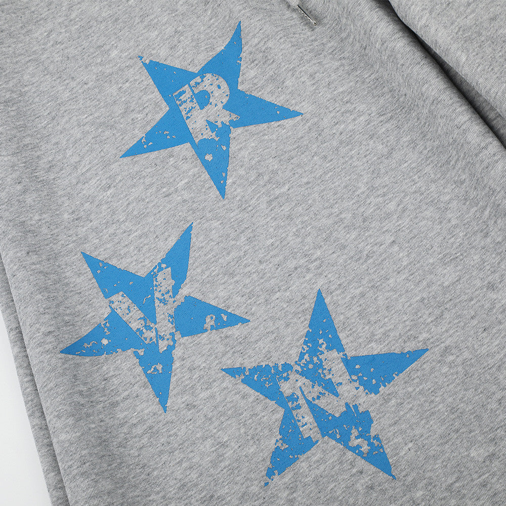 Close-up of blue star print on gray sweatpants leg