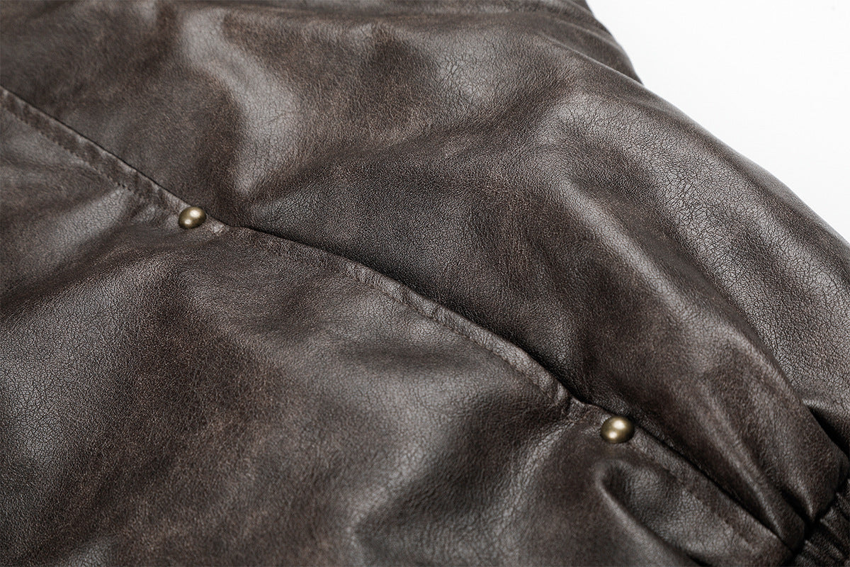 Close-up of brown faux leather sleeve seam with small metal snap details