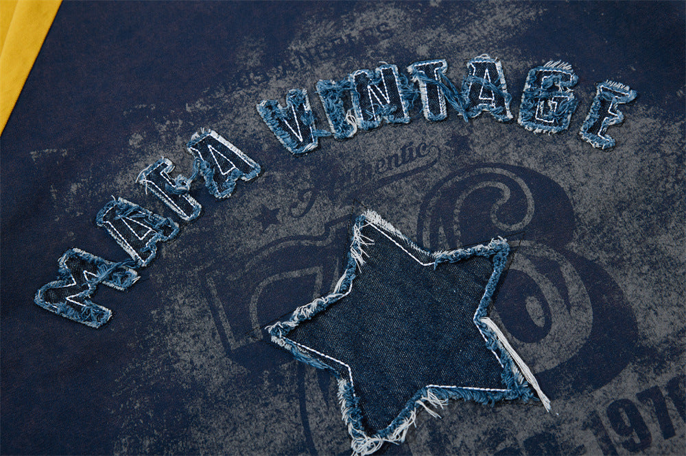Close-up of navy vintage T-shirt with frayed denim star patch and distressed Mafa Vintage lettering across the chest