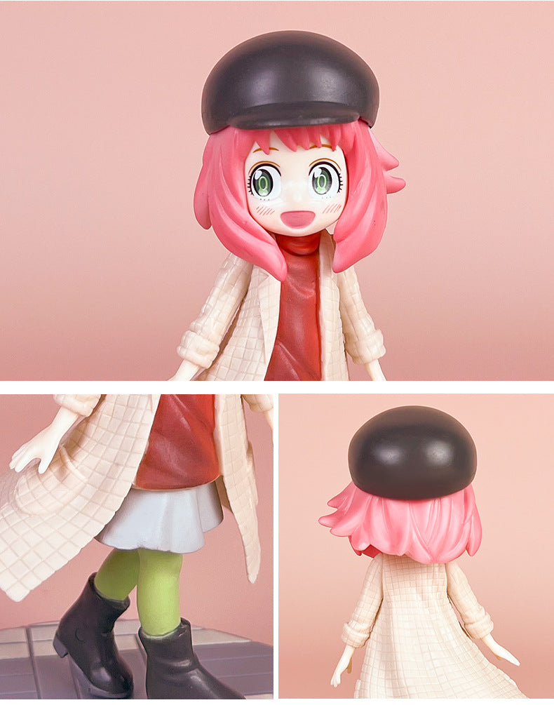 The Spy x Family Detective Anya PVC Figure Set showcases a 14 cm figure of Anya in the movie version, featuring four poses. She has pink hair and a black hat, wearing a beige coat over a red top and green leggings with a blue skirt. Her black boots stand out against the pink background.