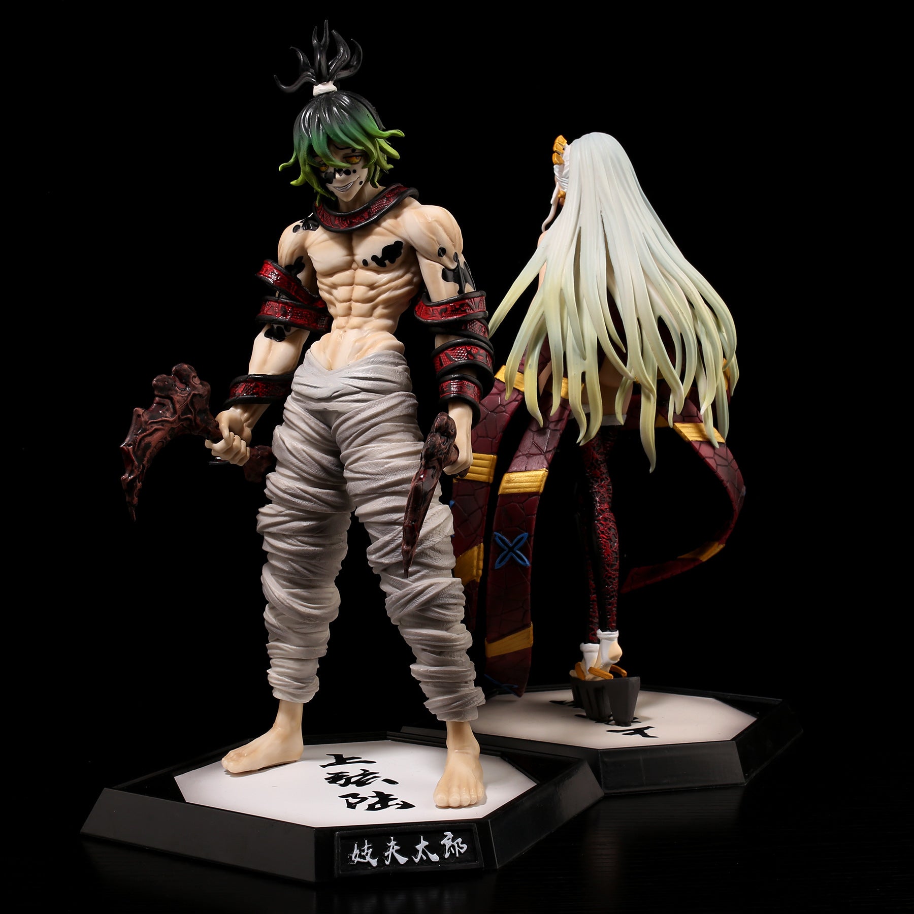 Two intricate anime figurines, highlighted by a Gyutaro Demon Slayer Figure – 29CM PVC from Kimetsu no Yaiba, feature vibrant designs. One sports green hair and muscular arms with a weapon, while the other has long white hair and a decorative outfit—ideal for action figure enthusiasts.