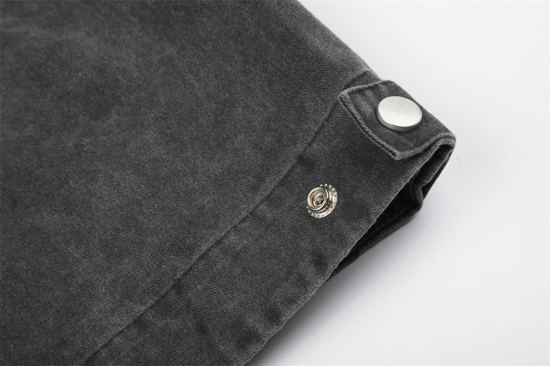 Close-up of black jacket sleeve cuff with snap button tab