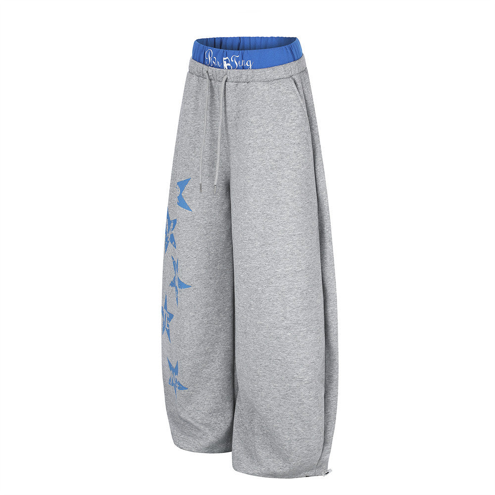 Gray wide-leg sweatpants, angled side view with blue star print along one leg