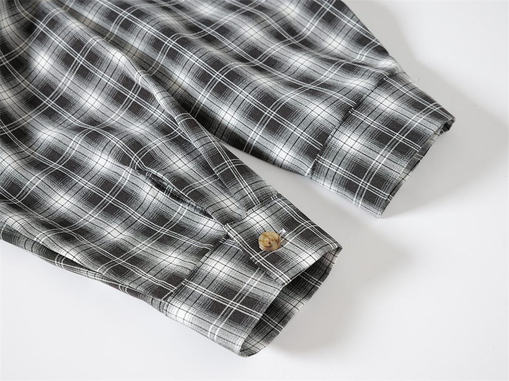 Close-up of black plaid shirt sleeve cuff with button