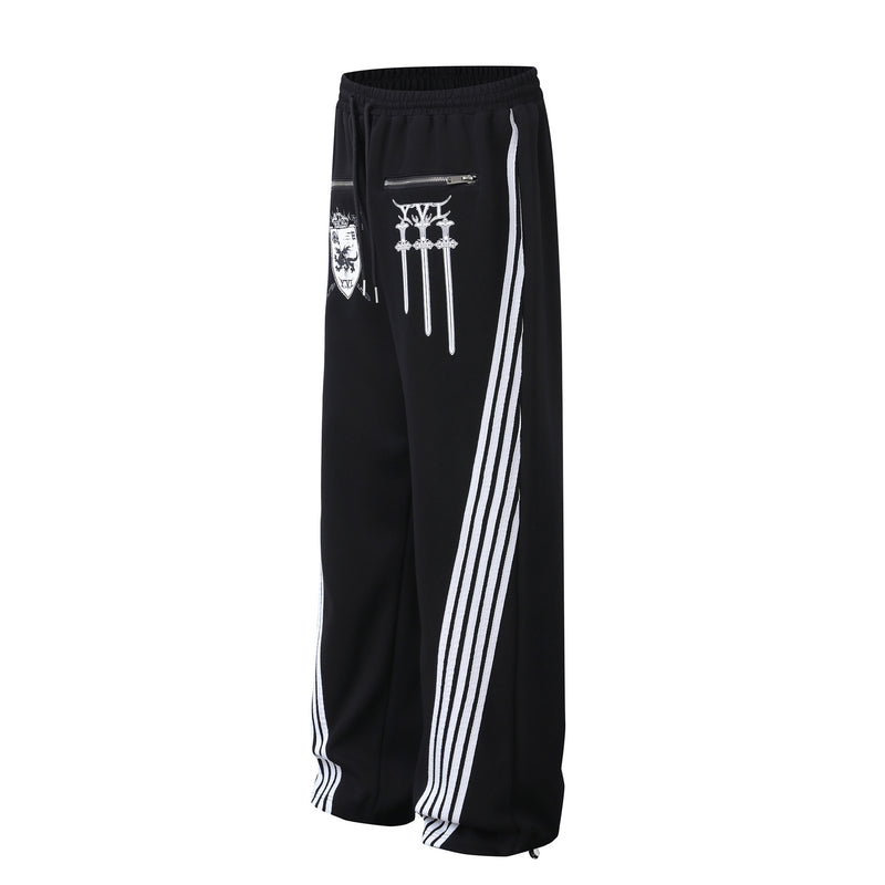 Pantalon de survêtement à jambes larges avec graphisme héraldique et détails latéraux multibandes