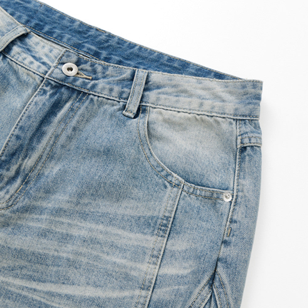 Close-up of front pocket and waistband on light blue faded denim shorts