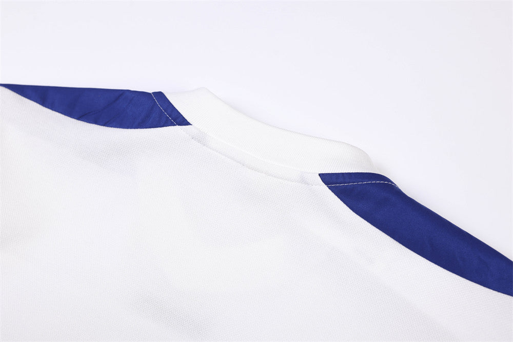 Close-up of white V-neck collar and blue shoulder panel stitching