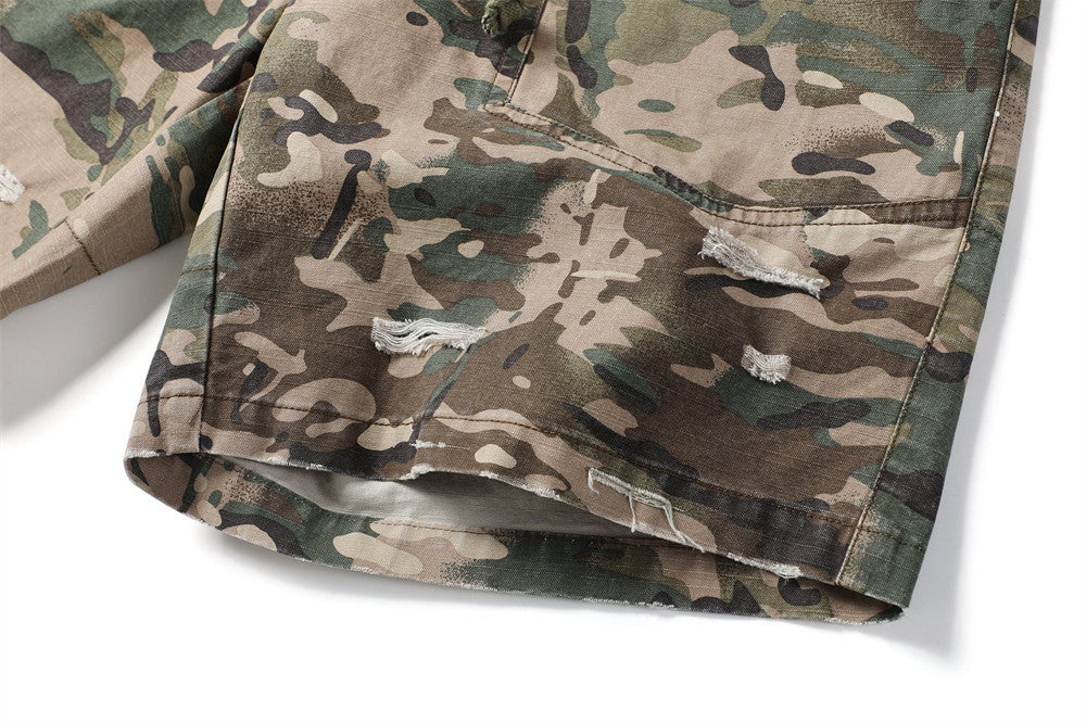Close-up of camouflage shorts leg opening with distressed patch details