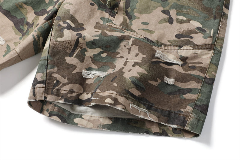 Close-up of camouflage shorts leg opening with distressed patch details