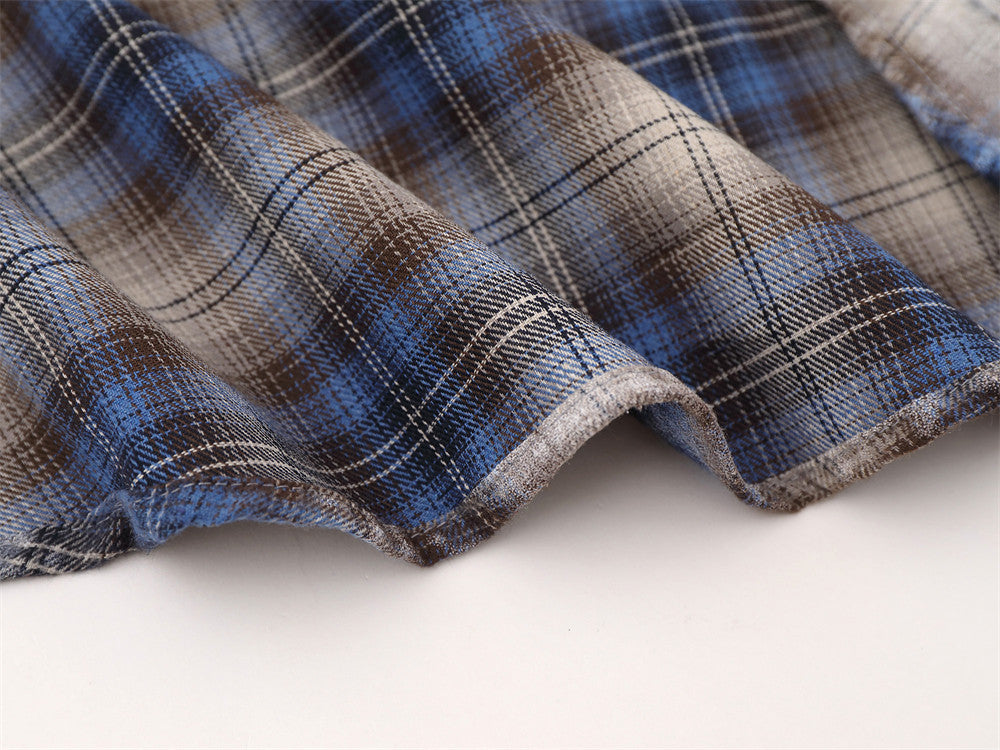 Close-up of shirt hem stitching on blue plaid flannel