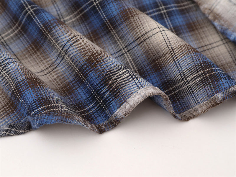 Close-up of shirt hem stitching on blue plaid flannel