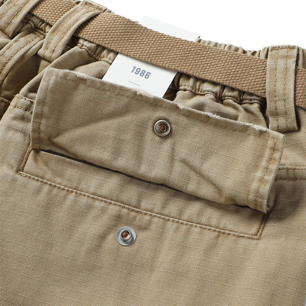 Close-up of khaki cargo shorts back flap pocket with snap closure and waistband label
