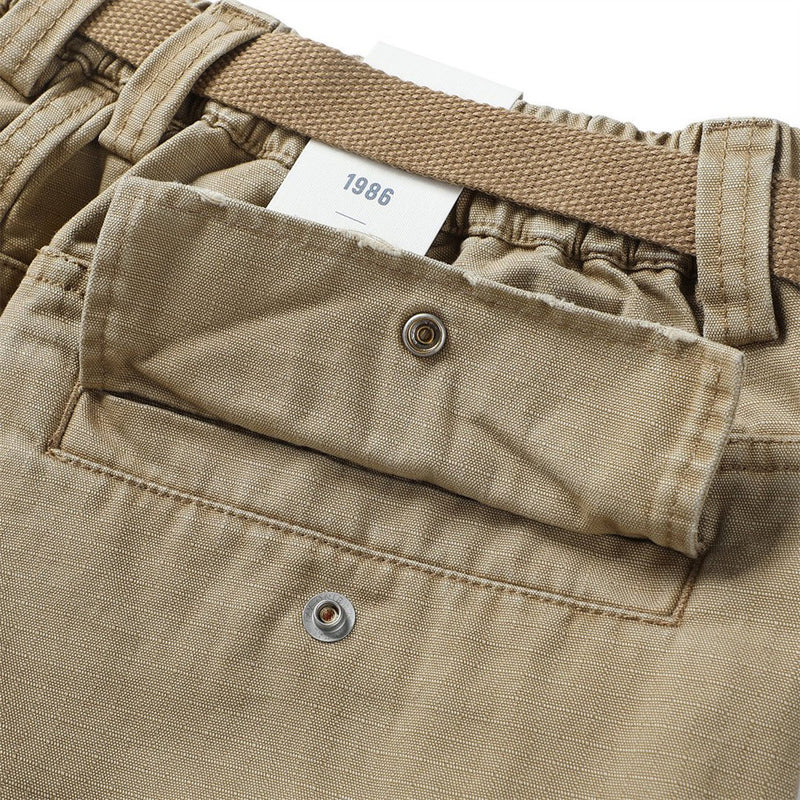 Close-up of khaki cargo shorts back flap pocket with snap closure and waistband label