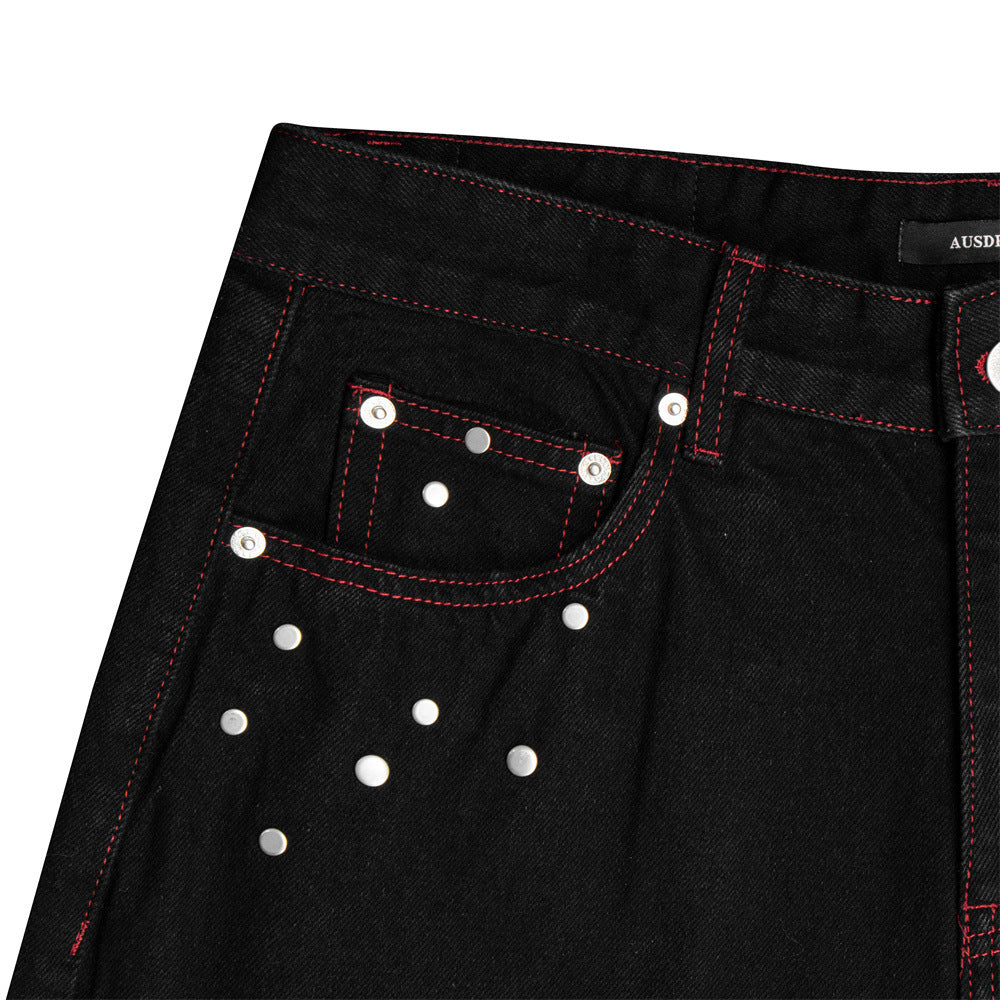 Jean homme noir à jambes larges, surpiqûres rouges contrastées, broderie étoile et clous