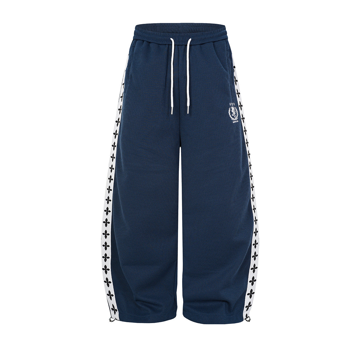 Pantalon de survêtement oversize à jambes larges en maille gaufrée bleu marine, avec bande latérale fleur de lys blanche et logo d’écusson brodé