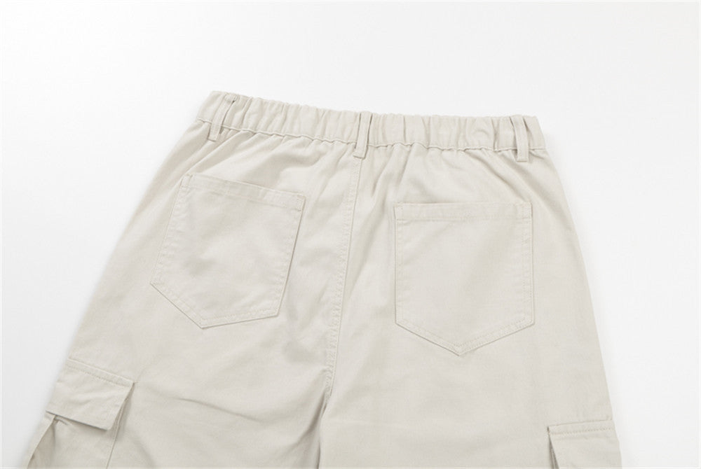 Close-up of cream pants back pockets and elastic waistband