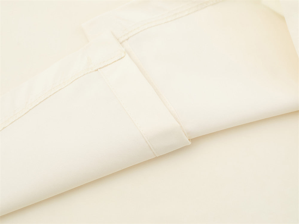 Close-up of cream shirt sleeve seam and folded cuff detail