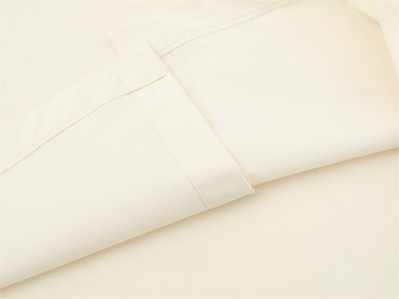 Close-up of cream shirt sleeve seam and folded cuff detail