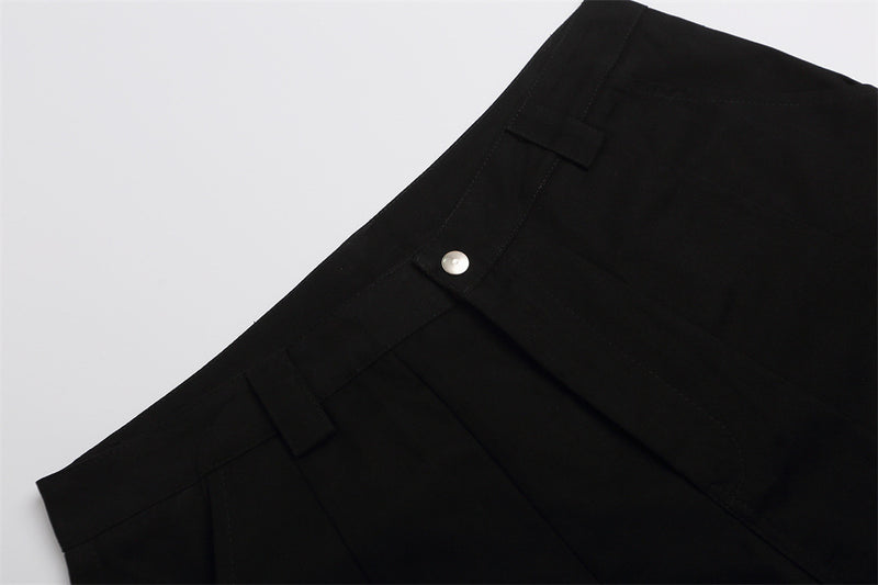 Close-up of black shorts waistband with snap button and belt loops