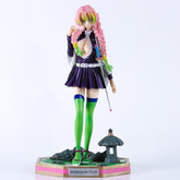 The Kanroji Mitsuri Action Figure from Demon Slayer shows her with pink hair and green highlights in braided pigtails, wearing a dark purple and white ensemble with green over-the-knee socks and red sandals, alongside a stone lantern. This 25cm high-quality collectible is perfect for enthusiasts.