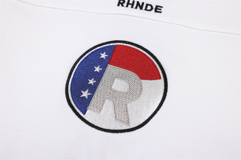 Close-up of embroidered circular R logo on white sports jersey