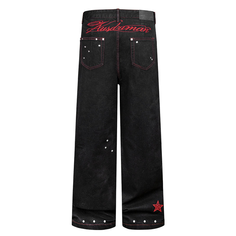 Jean homme noir à jambes larges, surpiqûres rouges contrastées, broderie étoile et clous