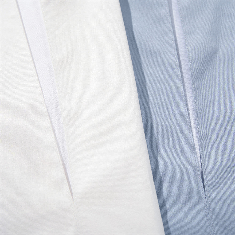 Close-up of white and light blue shirt fronts showing the layered V-neck opening