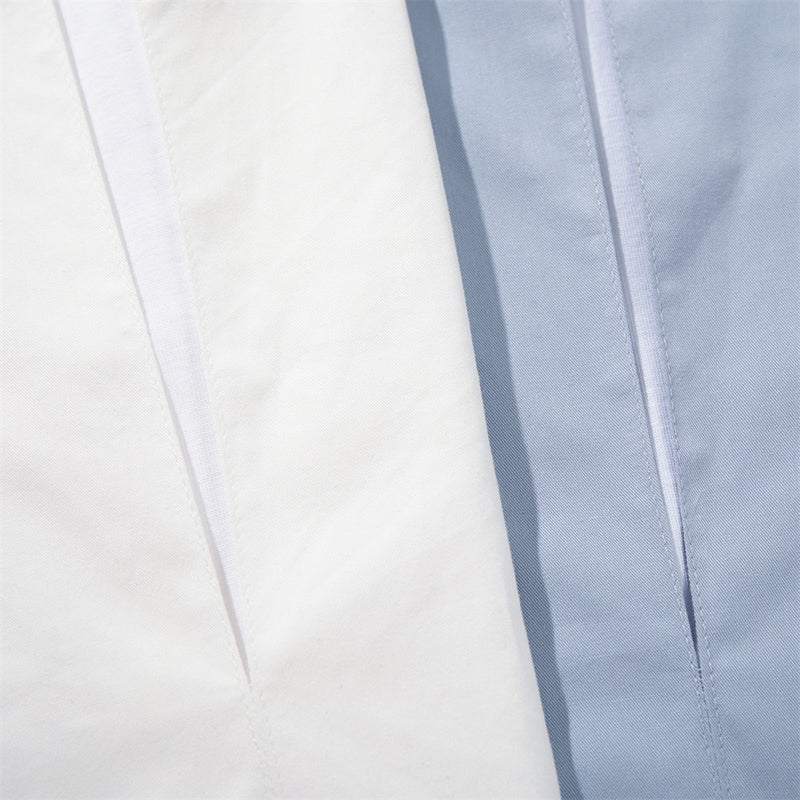 Close-up of white and light blue shirt fronts showing the layered V-neck opening