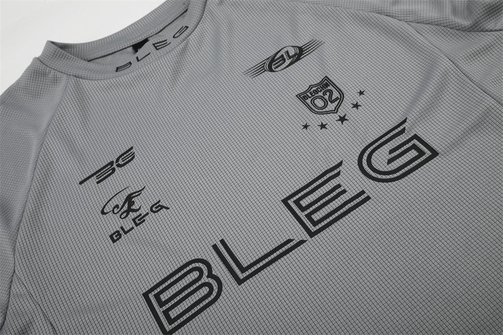 Close-up of gray shirt front with black racing logos and large BLEG print