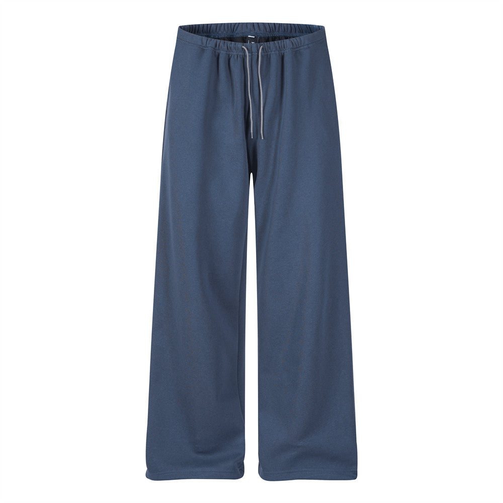 Men's baggy wide-leg track pants in slate blue with drawstring waist and back graphic crest pocket print