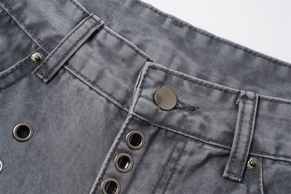 Close-up of grey denim waistband with button closure, belt loops, and metal eyelets