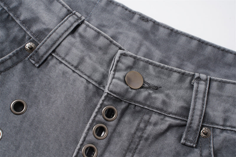 Close-up of grey denim waistband with button closure, belt loops, and metal eyelets