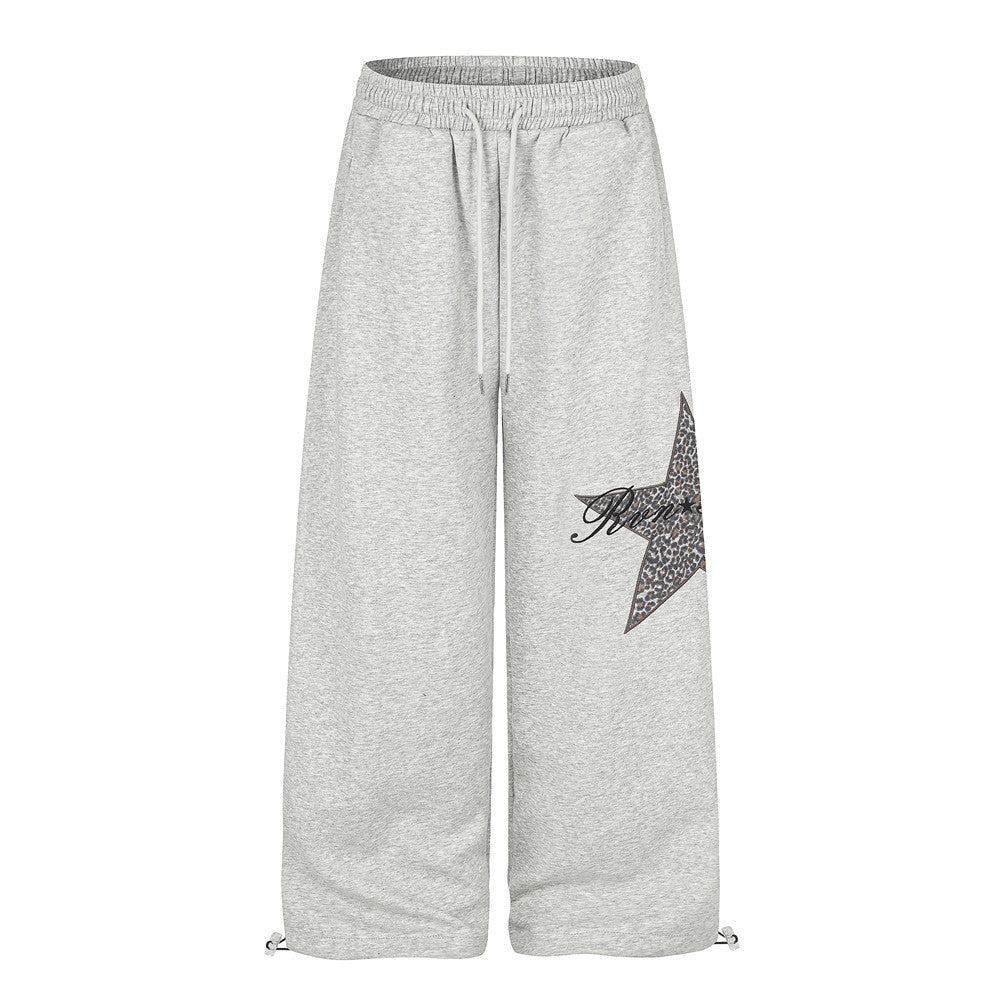Gray wide-leg sweatpants with leopard star patch, front view with drawstring hems