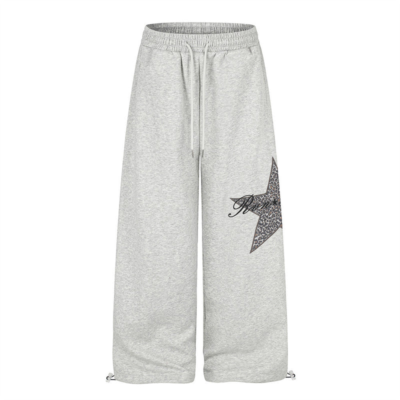 Gray wide-leg sweatpants with leopard star patch, front view with drawstring hems