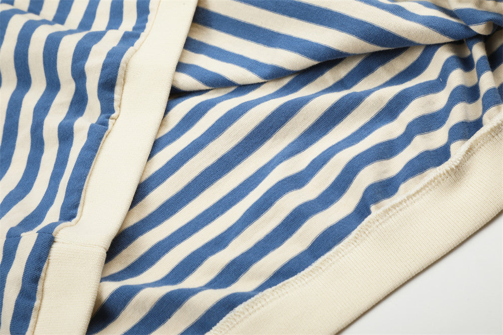 Close-up of blue and cream striped shirt fabric and stitched hem seam