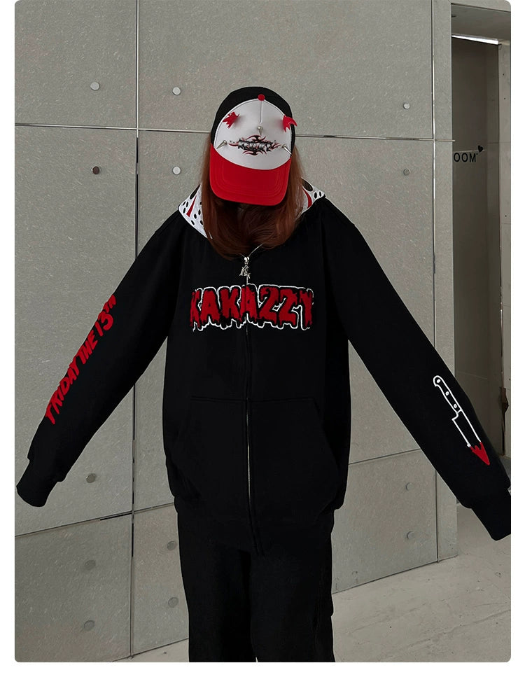 A horror movie fan stands against a plain gray background wearing a black Seakoff Friday the 13th hoodie with &quot;Kakazzy&quot; on the front and red &quot;From Me 17&