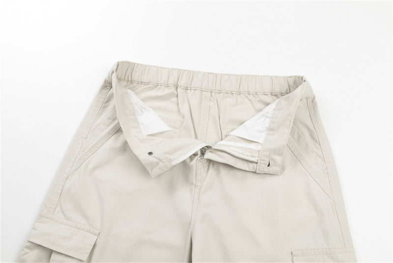 Close-up of cream cargo pants waistband and open fly