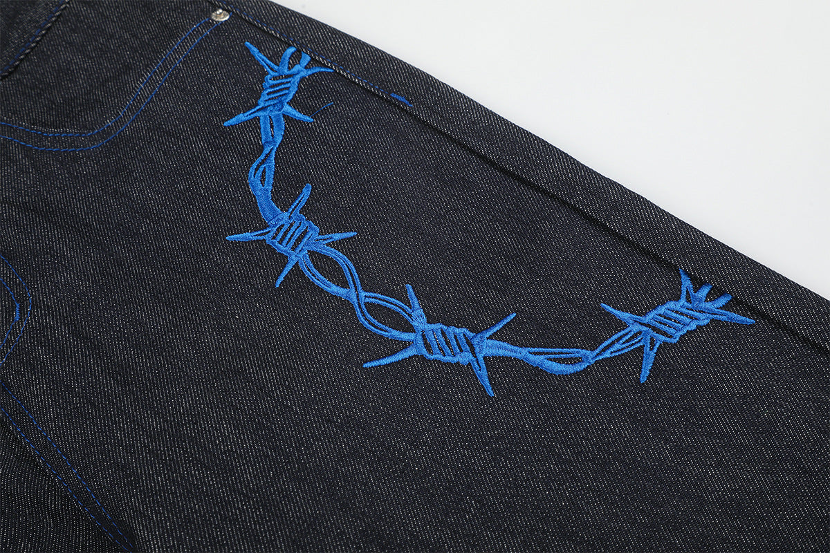 Jean baggy à jambes larges avec broderie bleue effet script et fil barbelé