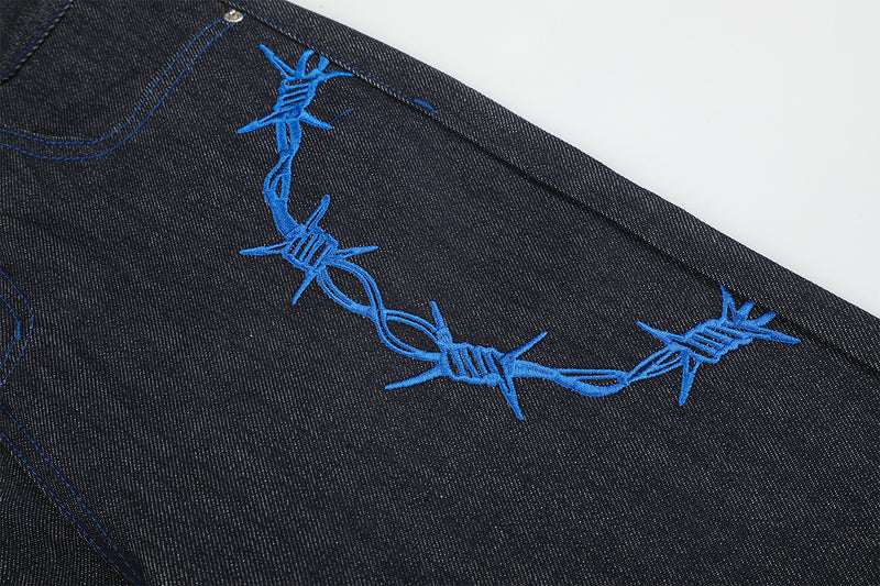 Jean baggy à jambes larges avec broderie bleue effet script et fil barbelé