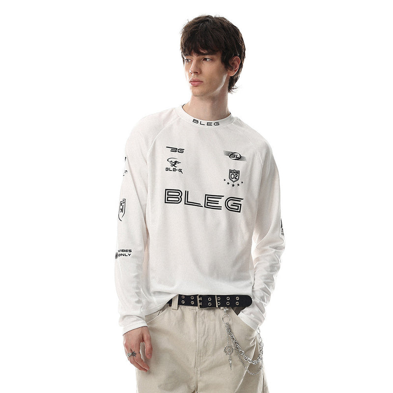 White long sleeve crew neck shirt worn by model with black racing-style logos on the chest