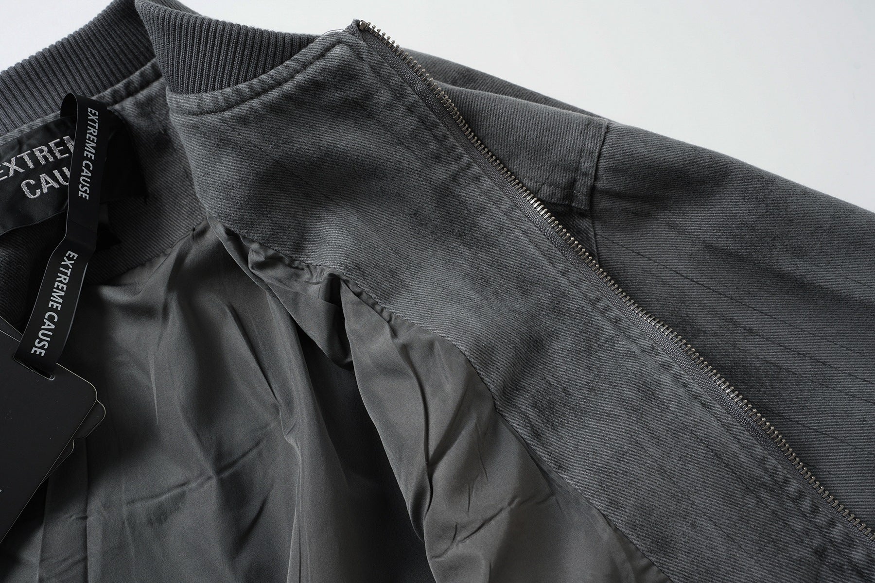 Veste bomber en jean délavé déconstruite à empiècement croisé et coutures effilochées