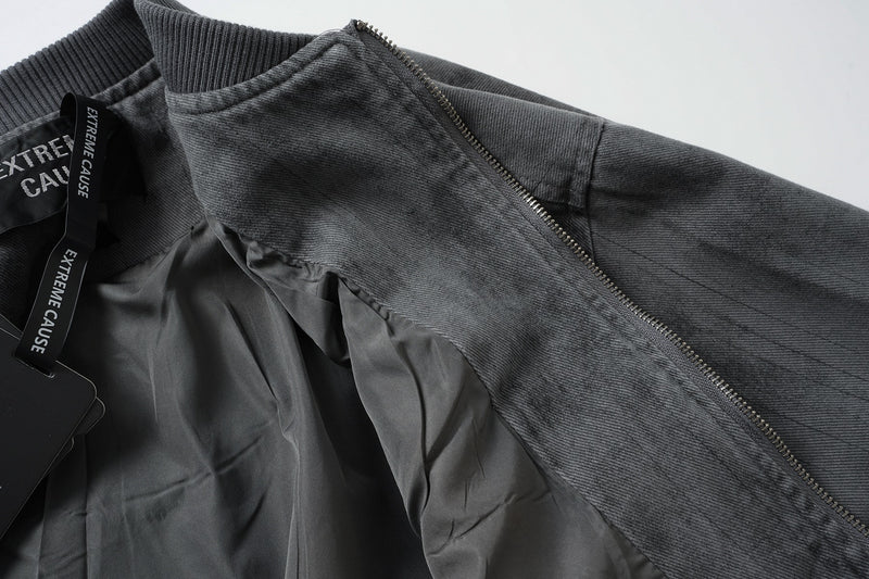 Veste bomber en jean délavé déconstruite à empiècement croisé et coutures effilochées
