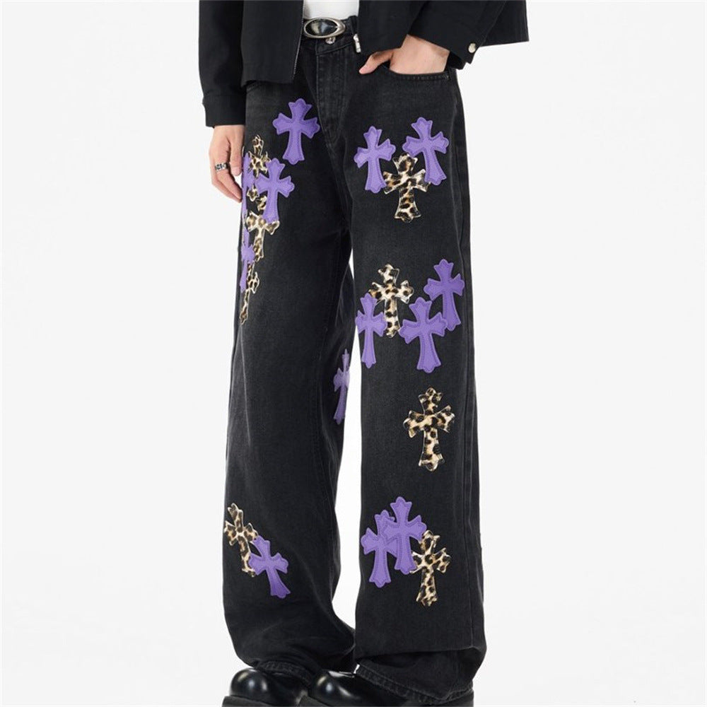 Black wide-leg jeans with purple and leopard cross patches, front view on model