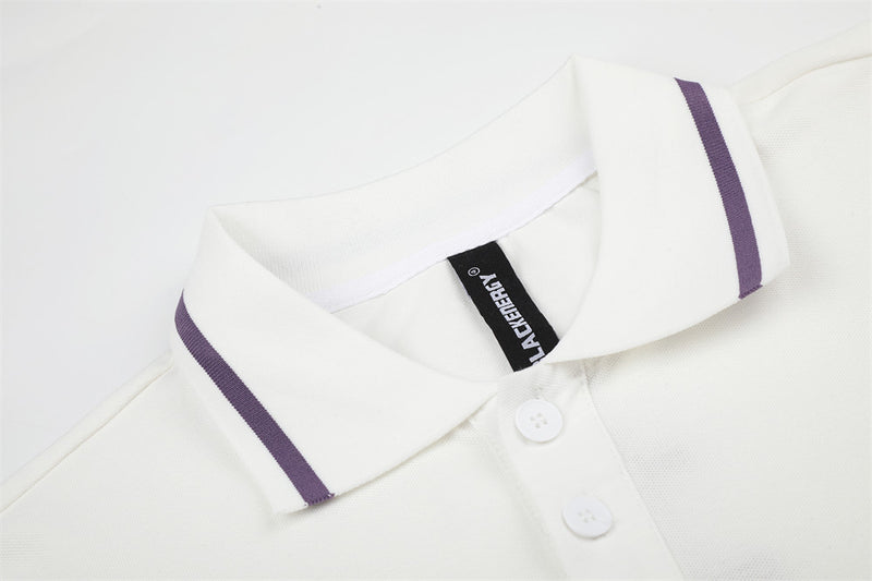 Close-up of white polo collar with purple stripe trim and button placket