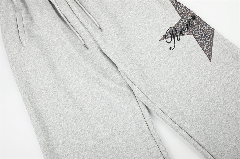 Gray sweatpants front leg view showing side seam and leopard star patch