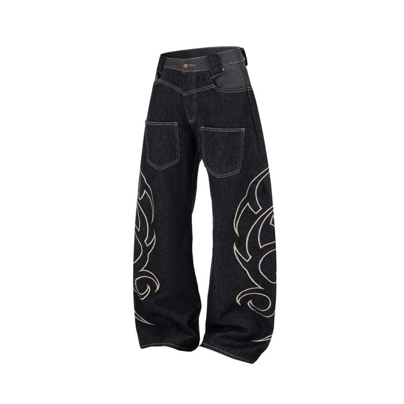 Angled front view of black baggy jeans with embroidered flame pattern on the legs