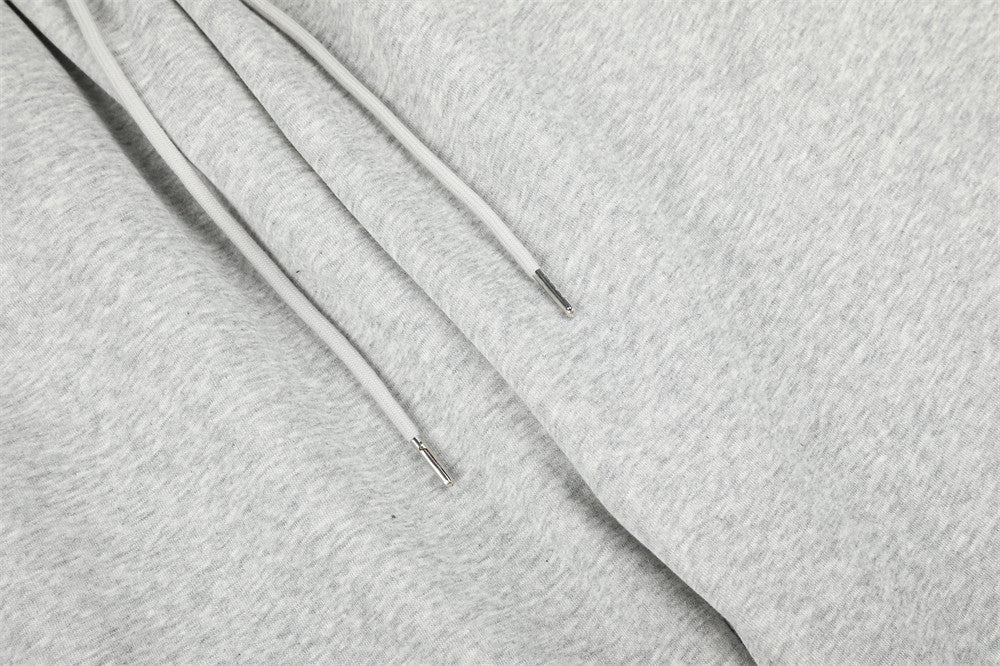 Close-up of gray sweatpants drawstring ends and soft heathered fabric
