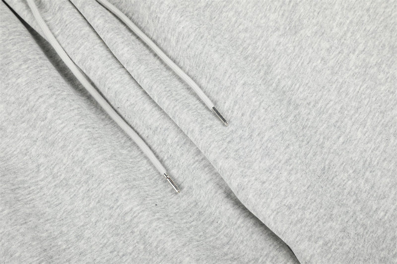 Close-up of gray sweatpants drawstring ends and soft heathered fabric